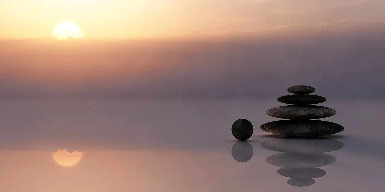 A serene landscape of stones balanced in a stack on a reflective surface